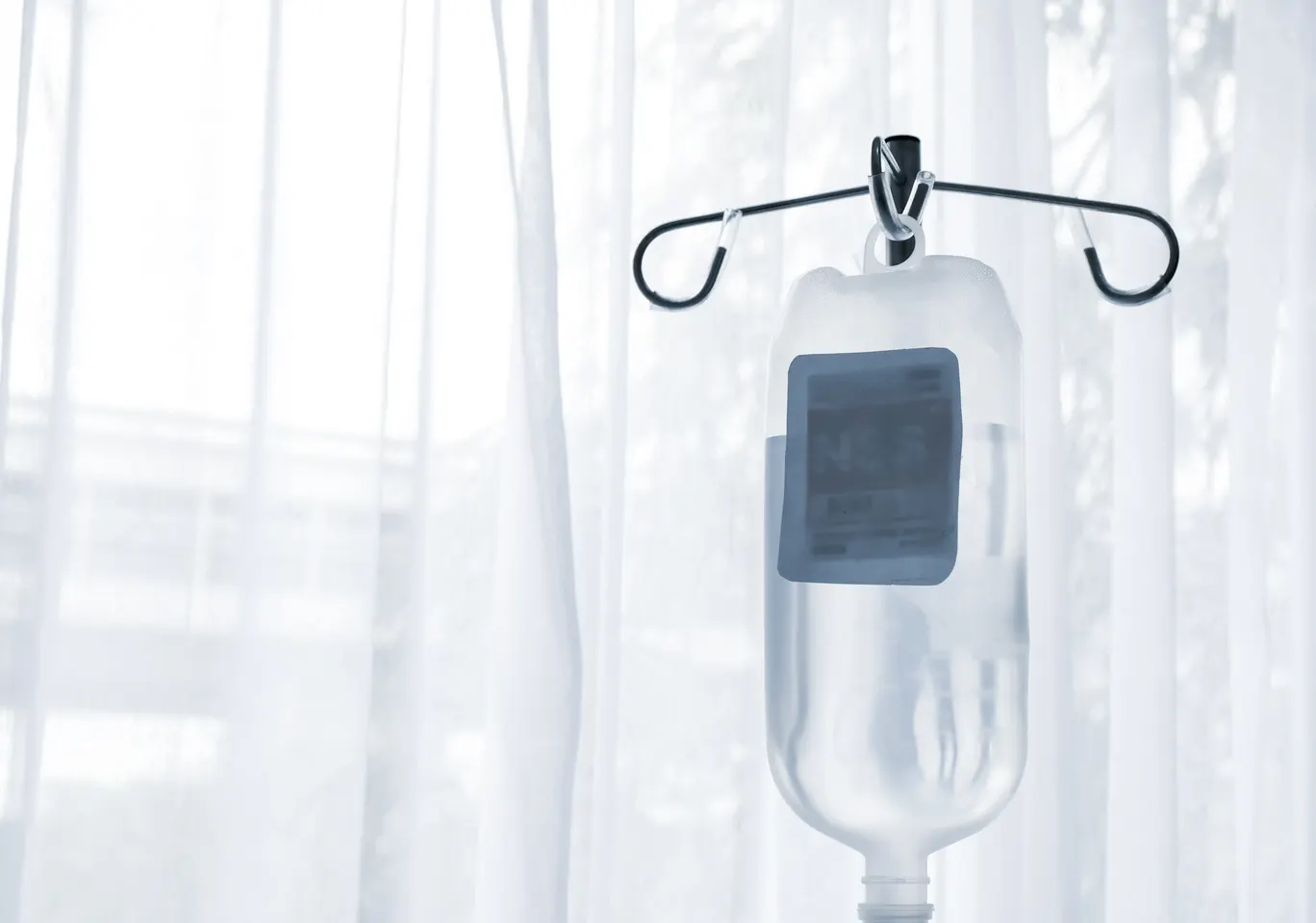 Kroplówki witaminowe Gostyń: butelka płynu infuzyjnego zawieszona przy oknie