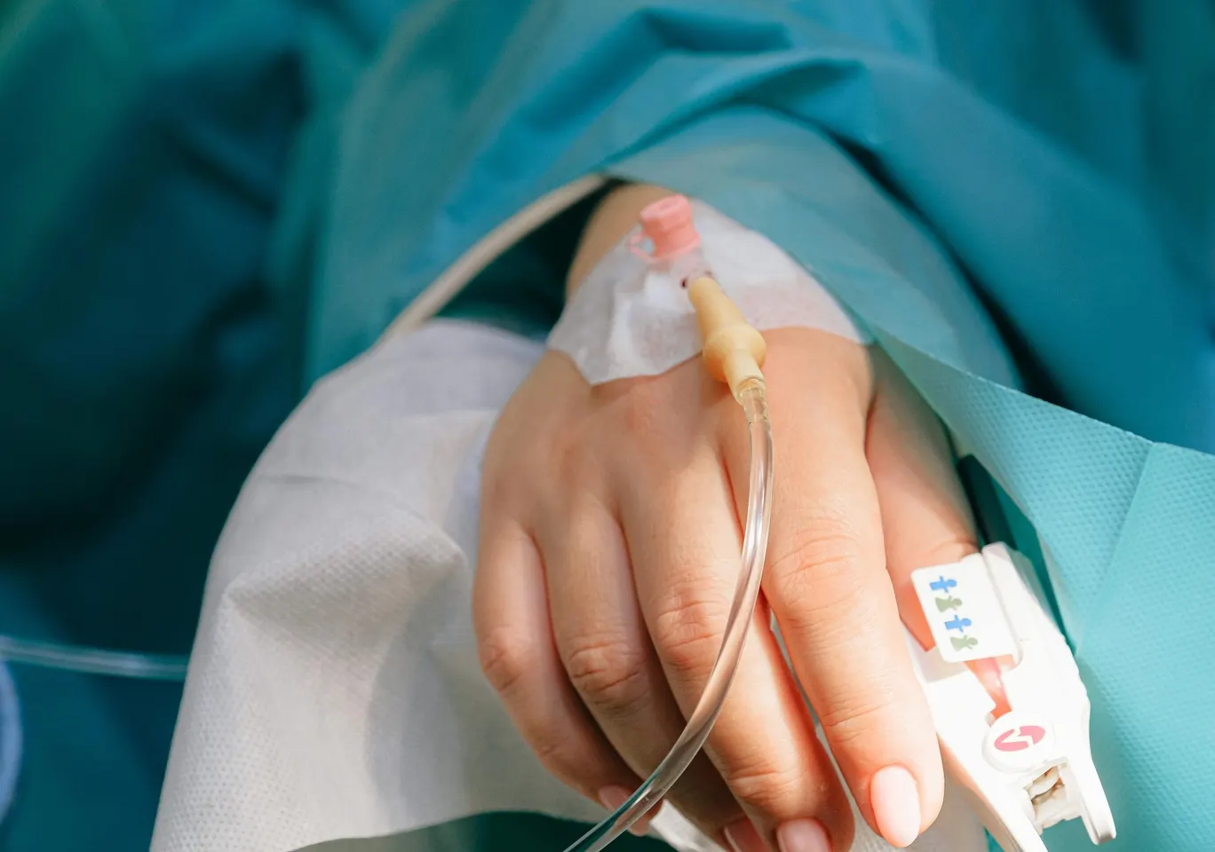 Detoks alkoholowy Kościan: dłoń z wenflonem i pulsoksymetrem pod nadzorem